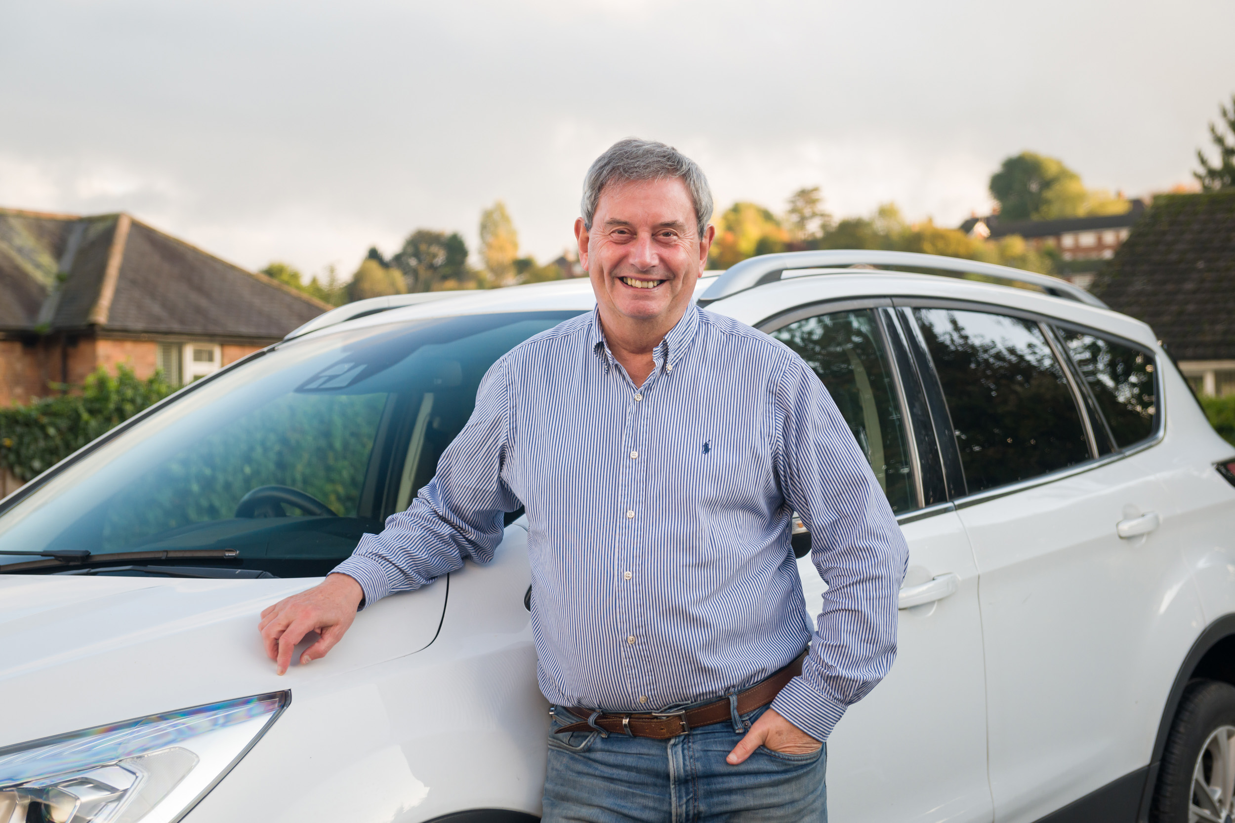 Smiling Open Homes Nottingham volunteer host standing by his car, ready to assist with transport for homeless young people in need of emergency accommodation.