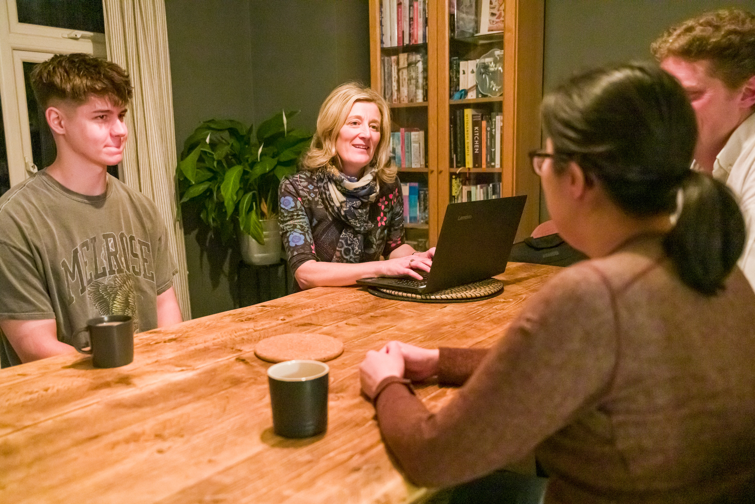 Open Homes Nottingham volunteer leading a discussion with young people around a wooden table, providing support for homeless youth